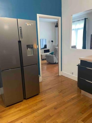 une cuisine avec un réfrigérateur en acier inoxydable dans une pièce dans l'établissement Manornella, beaux volumes, grand garage idéal Mas du Clos, à Aubusson