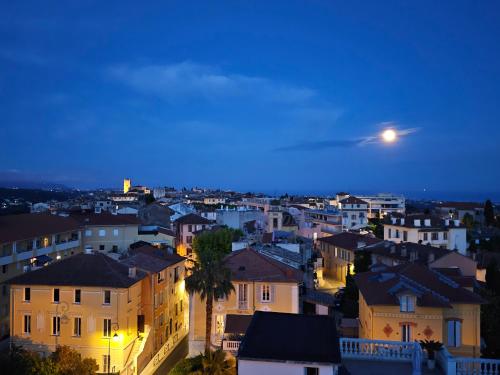 una vista de una ciudad por la noche con una luna en Hotel Diana, en Vence