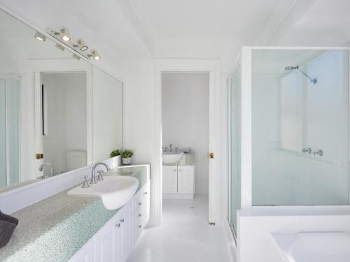 - une salle de bains blanche avec deux lavabos et une douche dans l'établissement Large, Light, dog friendly home 600m to Burleigh beach, à Gold Coast