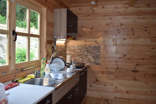 una cocina en una cabaña de madera con fregadero en Drinska Tisina en Ljubovija