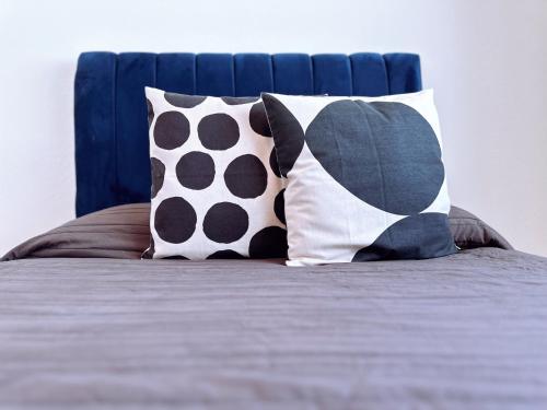 a bed with two pillows and a blue head board at House Hotel Stadium in Guadalajara