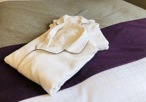 a white blanket sitting on top of a bed at Tokyu Stay Sapporo in Sapporo
