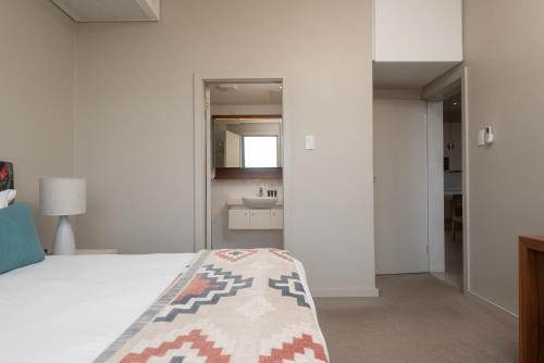 a white bedroom with a bed and a sink at Indigo 2 Bed Zimbali Suites Sea View in Ballito