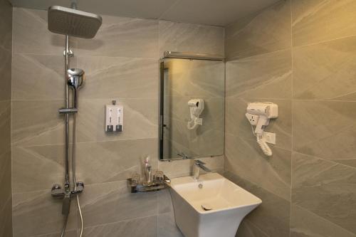 W łazience znajduje się umywalka oraz prysznic z lustrem. w obiekcie Lake View Hotel w mieście Hanoi