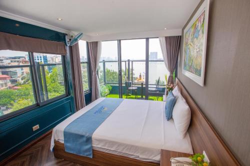 a bedroom with a large bed with a large window at Lake View Hotel in Hanoi