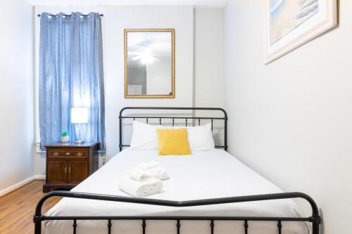a bedroom with a bed with a yellow pillow at Sunny Sweetheart-Front Apartment near Riverwalk in Columbus