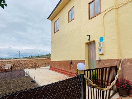 a building with a fence in front of it at Casa De La Era in Cuevas de Ayllón