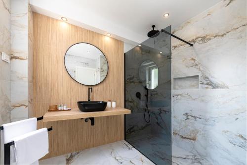 a bathroom with a sink and a mirror at K&N LuxApartment - Jacuzzi and Magnificent Sea view in Mlini