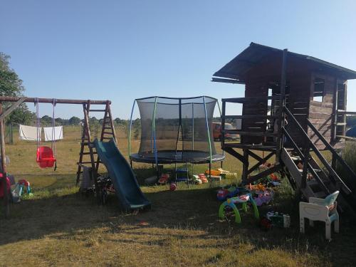 a playground with a slide and a swing at Peace & Quiet Pole Namiotowo-Kempingowe in Sławoborze