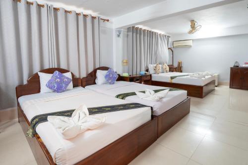 dwa łóżka w pokoju hotelowym z dwoma łóżkami w obiekcie Siem Reap Riverside Hotel w Siem Reap