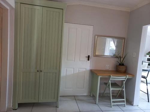 Cette chambre comprend un bureau, une porte et un miroir. dans l'établissement Lemon Tree Manor- Country Cottage, à Groblersdal