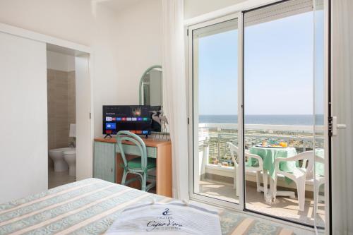a bedroom with a bed and a view of the ocean at Hotel Cigno D'Oro in Riccione