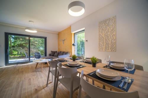a dining room and living room with a table and chairs at Holiday House U Hájenky 12P Lipno Home in Lipno nad Vltavou