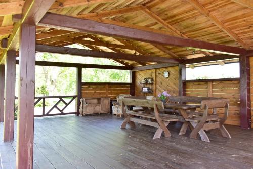 a wooden porch with a table and chairs in a cabin at Sodyba Puodžių Kaimas in Mackėnai