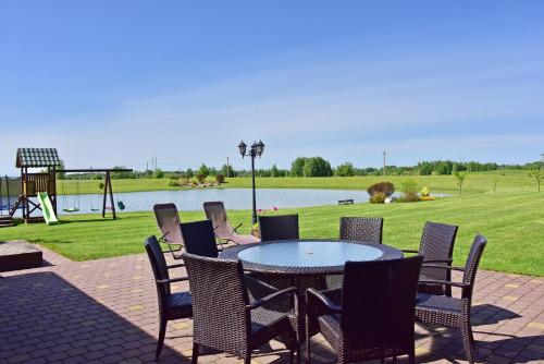 a patio with a table and chairs and a playground at Sodyba Puodžių Kaimas in Mackėnai