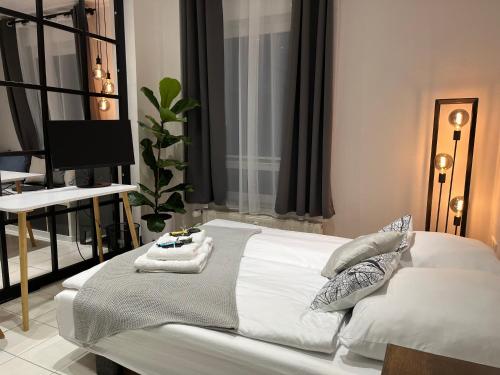 1 dormitorio con cama blanca y escritorio en BienveniDUS - self service apartment - Apartment zur Selbstversorgung - Das Messezimmer - Düsseldorf en Düsseldorf