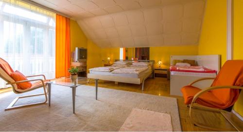 a room with two beds and a table and chairs at Eva Rooms in Budakeszi
