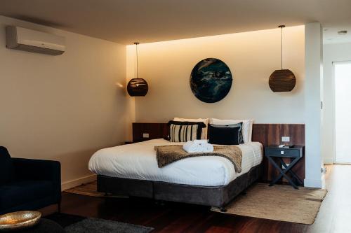 a bedroom with a bed and a black chair at Jaspers Cabins in Pemberton