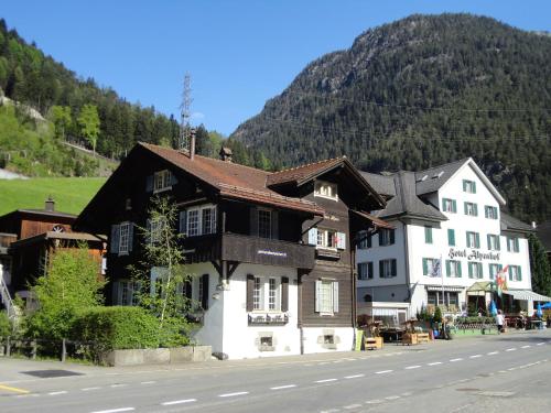 a building on the side of a street with a mountain at Gotthard Backpacker in Wassen