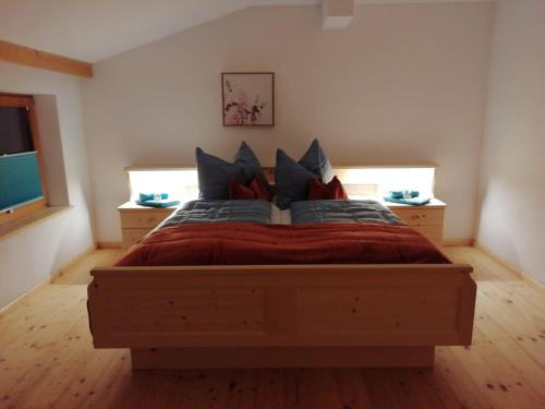 una camera da letto con un grande letto in legno con cuscini di Ferienwohnung Hinterschwarzenberg a Brixlegg