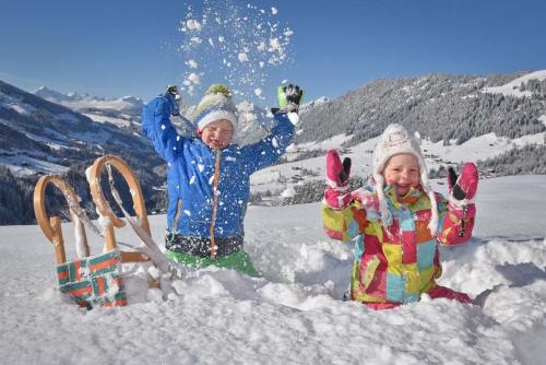 two young children are playing in the snow at Ferienwohnung Hinterschwarzenberg in Brixlegg