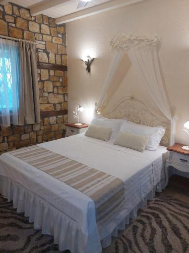 a bedroom with a white bed with a brick wall at The Stone Heaven in Galíni