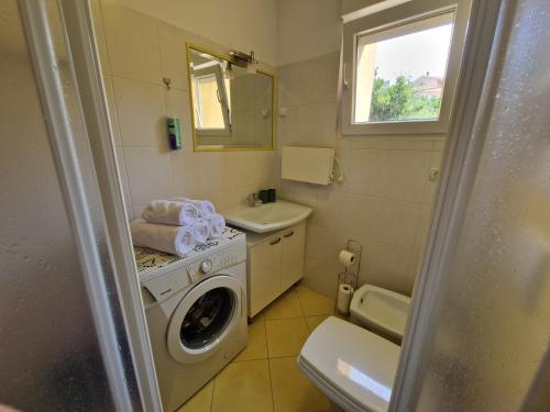 a bathroom with a washing machine and a sink at Apartment Sole Dorato in Rijeka