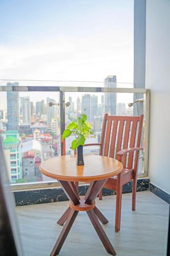 a wooden table and a chair in front of a window at Poulo Wai Hotel & Apartment in Phnom Penh