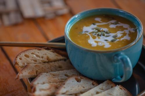 a blue cup of soup and some bread on a plate at Radhika Eco Resort(Odonata) in Arambol