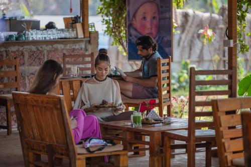 a group of people sitting at a table in a restaurant at Radhika Eco Resort(Odonata) in Arambol