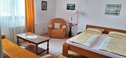 a small bedroom with a bed and a chair at Apartman UNA Travnik in Travnik