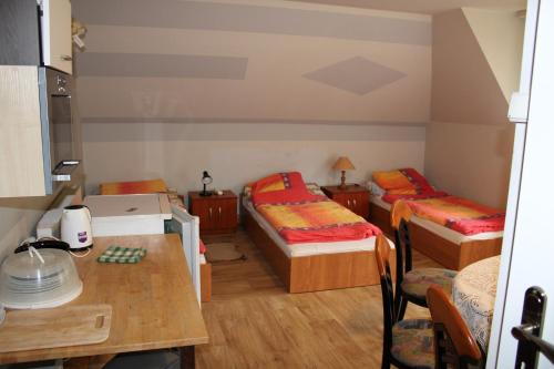 PorąbkaにあるPodelniskaのベッド2台とテーブルが備わる小さな客室です。