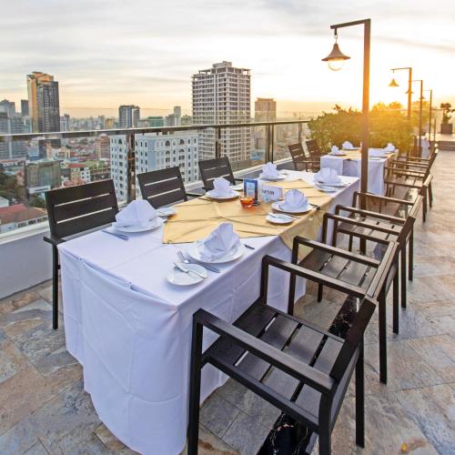 a row of tables and chairs on a roof at Poulo Wai Hotel & Apartment in Phnom Penh