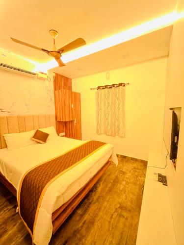 a bedroom with a bed and a flat screen tv at The Tendoinn in Pollāchi