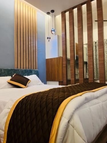 a bedroom with a large bed and a large window at The Tendoinn in Pollāchi