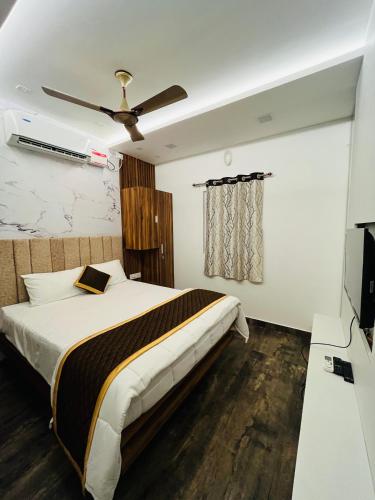 a bedroom with a bed and a ceiling fan at The Tendoinn in Pollāchi