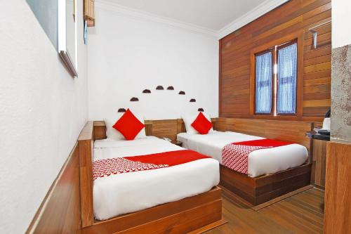 sypialnia z 2 łóżkami i czerwonymi poduszkami w obiekcie OYO 210 Hotel Five 2 w mieście Kota Kinabalu