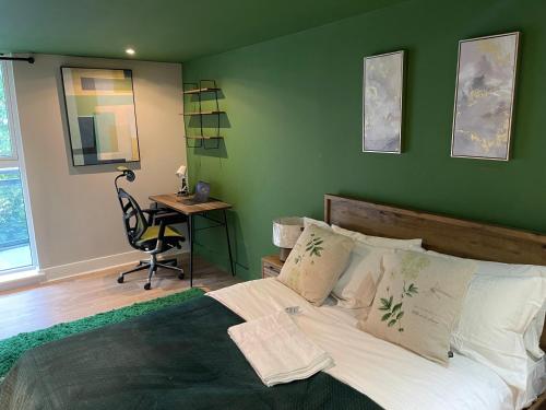 a bedroom with a bed with a green wall at 3BR Apt Near Excel, O2 & City Airport! in London
