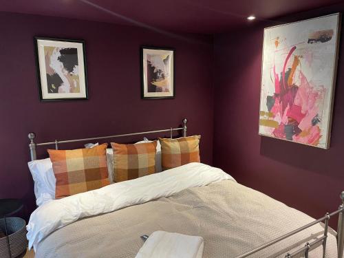 a bedroom with purple walls and a bed with pillows at 3BR Apt Near Excel, O2 & City Airport! in London