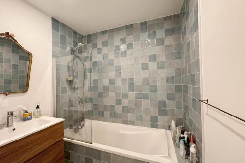 La salle de bains est pourvue d'une douche, d'une baignoire et d'un lavabo. dans l'établissement Cosy, calm 70m2, 2 bedroom flat., à Paris