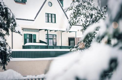 a white house with snow on the ground at Parkhotel Holzner in Soprabolzano