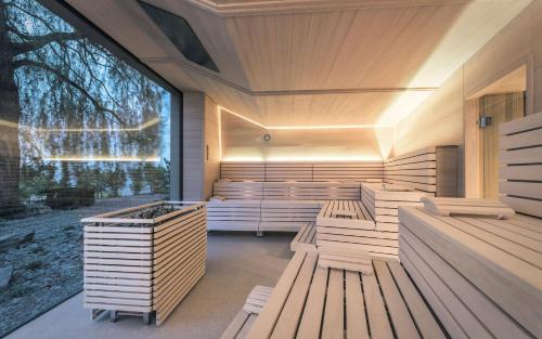a sauna with wooden benches and a large window at Parkhotel Holzner in Soprabolzano