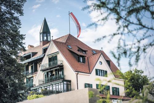 - un bâtiment avec une cloche en haut dans l'établissement Parkhotel Holzner, à Soprabolzano