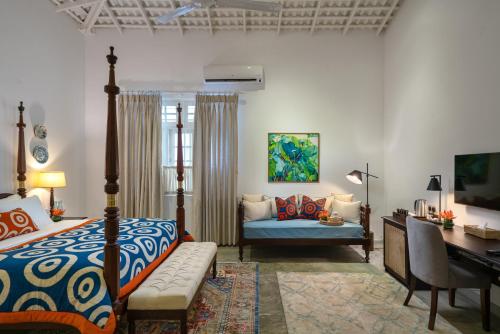 - une chambre avec un lit, un canapé et un bureau dans l'établissement Ceylo Villas, à Bentota