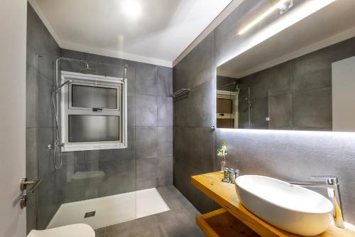 ein Bad mit einem Waschbecken und einer Dusche in der Unterkunft Mackenzie Beachfront Eftyhia Suite in Larnaka