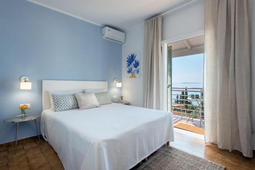 sypialnia z białym łóżkiem i widokiem na ocean w obiekcie Reana Elegant Apartments w mieście Barbati