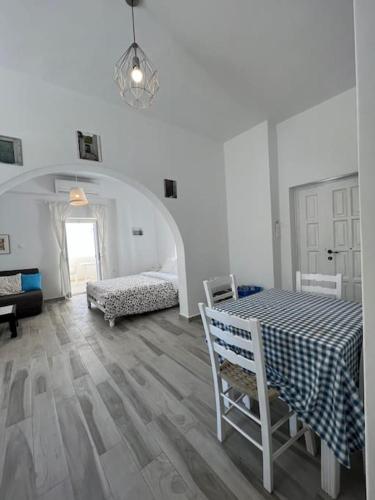 Una habitación blanca con una mesa y un dormitorio. en Naxian Castle Gem Studio, en Naxos Chora