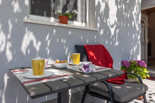 een grijze tafel met twee kopjes koffie erop bij Apartments Roza in Mlini