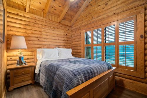 um quarto com uma cama num chalé de madeira em Oak Hill Cabin em Somerset