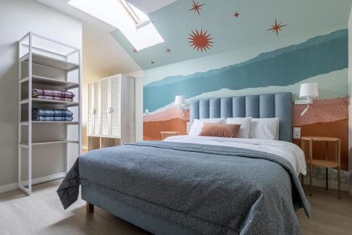 a bedroom with a large bed with a blue headboard at Zacisze Lubiatowo in Lubiatowo